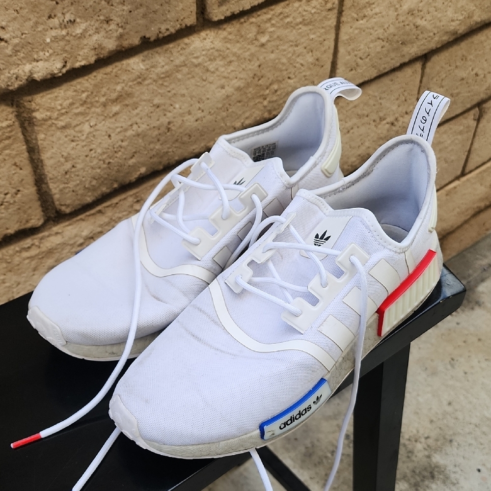 Adidas NMD R1 in a white colorway with red and blue accents.